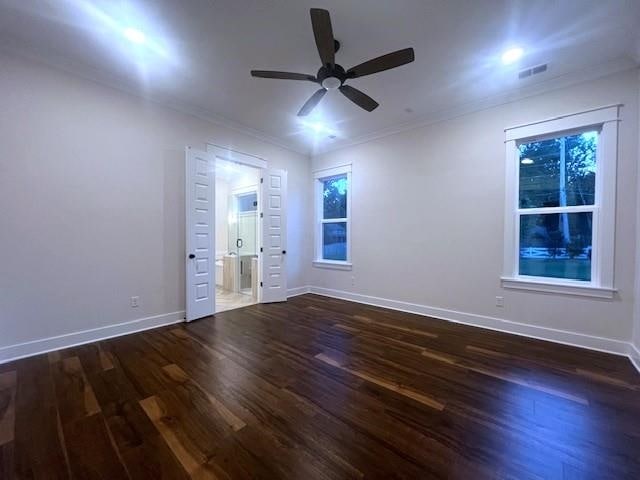 empty room featuring dark hardwood / wood-style flooring, ceiling fan, and ornamental molding