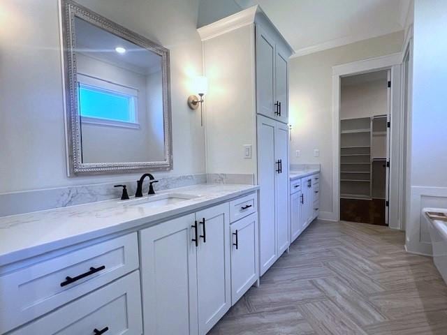 bathroom with a bath, vanity, parquet floors, and crown molding