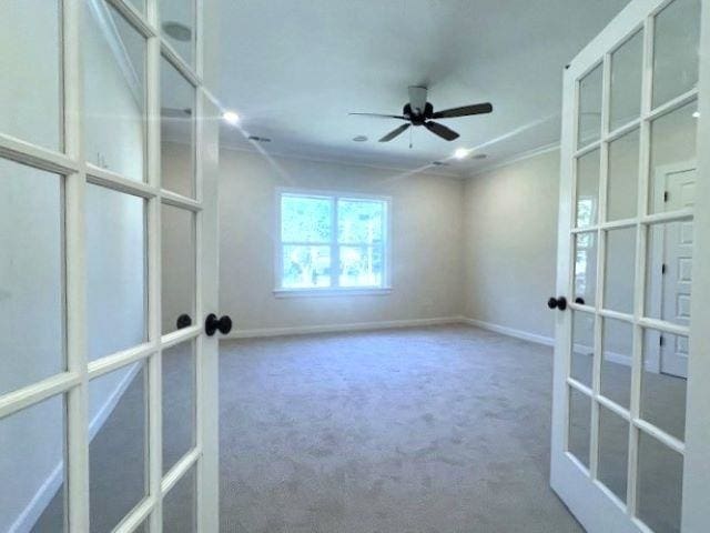 spare room with french doors, carpet floors, ceiling fan, and crown molding