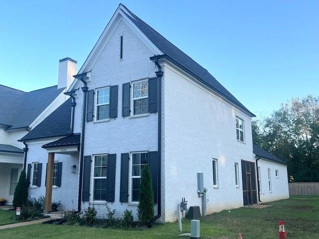 view of side of property with a lawn