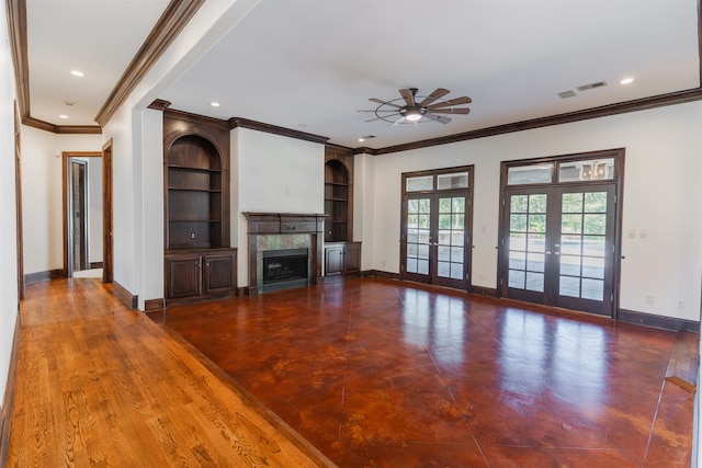 unfurnished living room with built in features, ceiling fan, crown molding, dark hardwood / wood-style flooring, and french doors