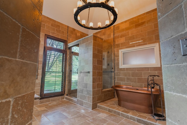 bathroom with separate shower and tub, a chandelier, and tile walls