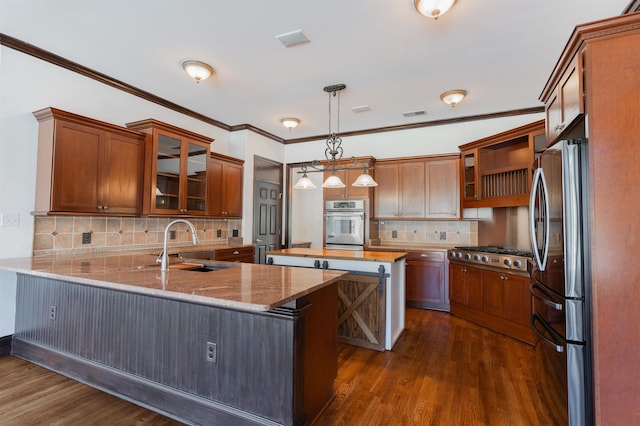 kitchen featuring decorative backsplash, sink, dark hardwood / wood-style flooring, appliances with stainless steel finishes, and decorative light fixtures