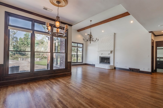 unfurnished living room featuring vaulted ceiling with beams, a brick fireplace, a chandelier, dark hardwood / wood-style floors, and crown molding