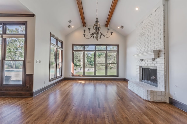 unfurnished living room featuring a notable chandelier, hardwood / wood-style flooring, a fireplace, and beamed ceiling