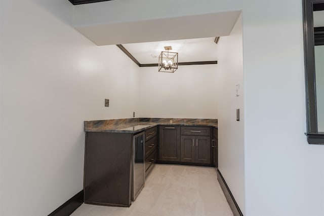 bar featuring ornamental molding, dark brown cabinetry, a chandelier, and light carpet