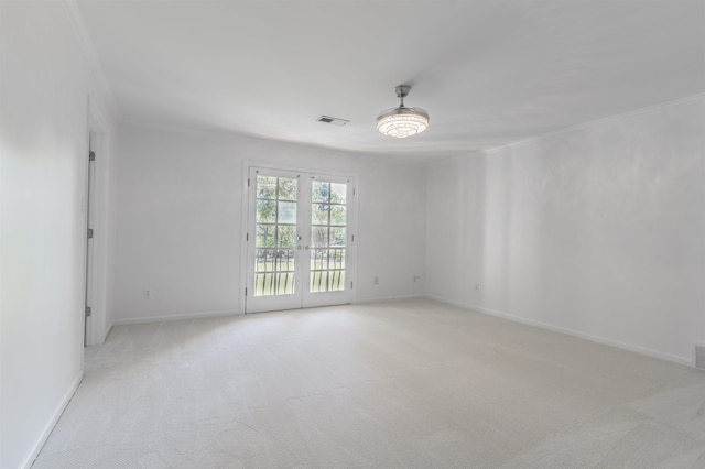 carpeted empty room with ornamental molding and french doors