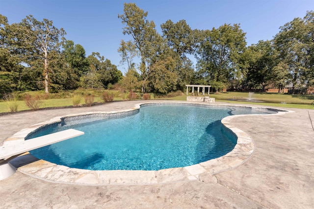 view of swimming pool with a diving board, a yard, and a patio area