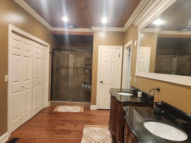 bathroom featuring wood-type flooring, vanity, ornamental molding, and a shower with door