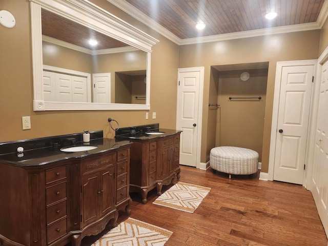 bathroom with ornamental molding, hardwood / wood-style flooring, and vanity