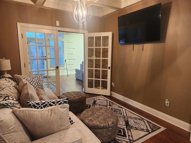 living room featuring ornamental molding, wood-type flooring, french doors, a chandelier, and coffered ceiling