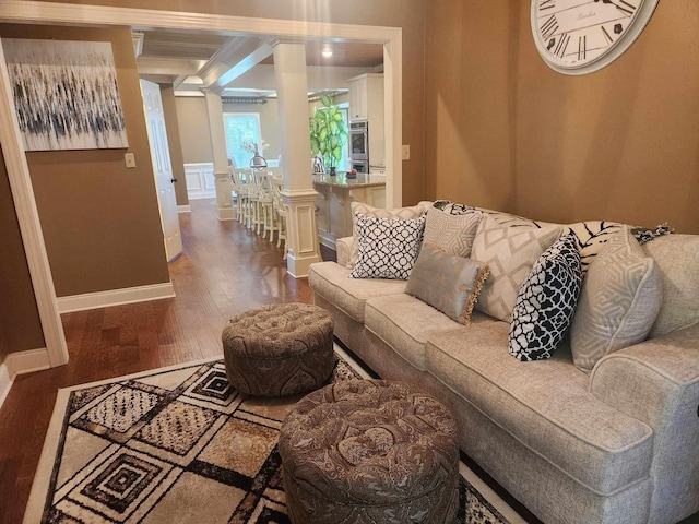 living room featuring decorative columns and dark hardwood / wood-style flooring