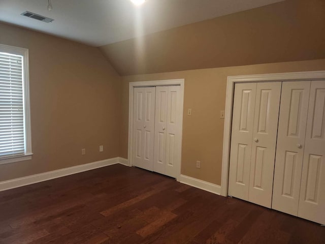 unfurnished bedroom featuring lofted ceiling and dark hardwood / wood-style flooring