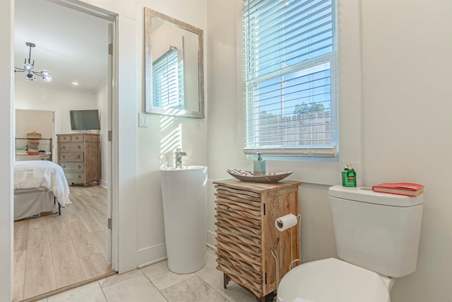 bathroom with ornamental molding, hardwood / wood-style flooring, plenty of natural light, and toilet