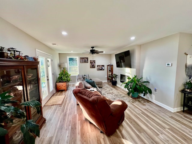 living room featuring light hardwood / wood-style flooring and ceiling fan