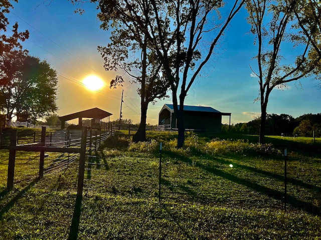 yard at dusk with an outbuilding and a rural view