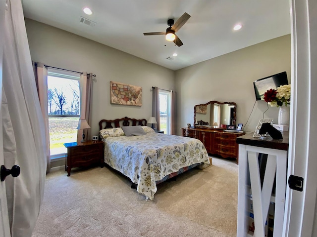 bedroom featuring light carpet, multiple windows, and ceiling fan