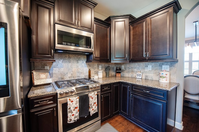 kitchen with light stone counters, dark hardwood / wood-style floors, decorative backsplash, and stainless steel appliances