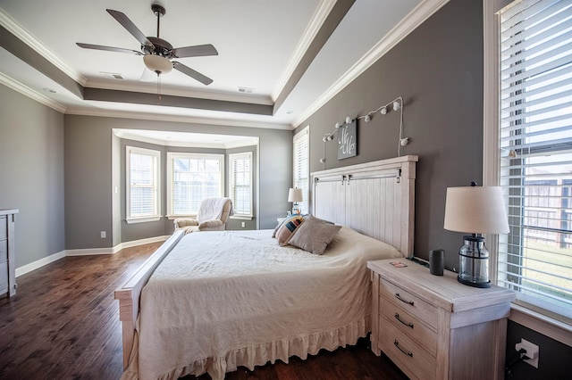 bedroom featuring ornamental molding, ceiling fan, a tray ceiling, and dark hardwood / wood-style floors