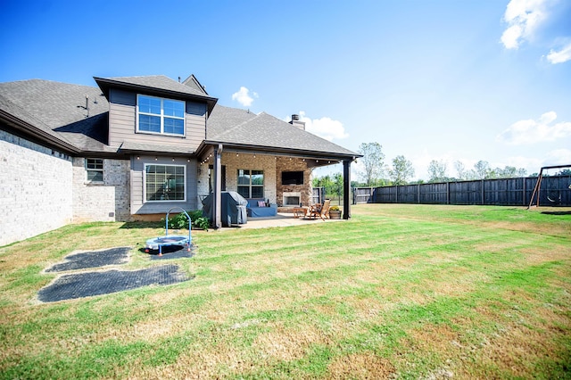 back of property with a lawn and a patio area