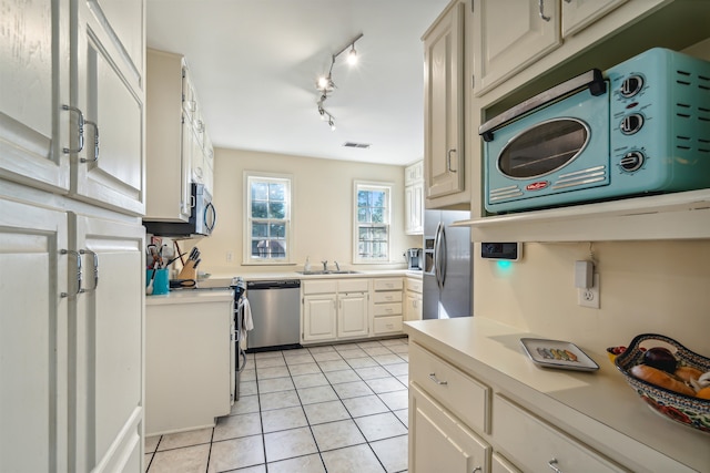 kitchen with light tile patterned floors, sink, and stainless steel appliances