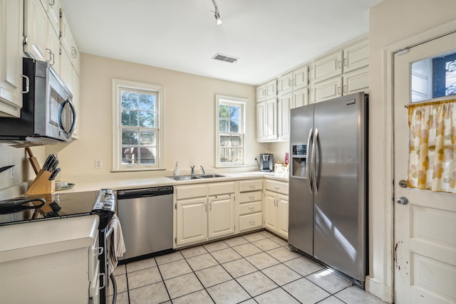 kitchen featuring appliances with stainless steel finishes, sink, and light tile patterned floors