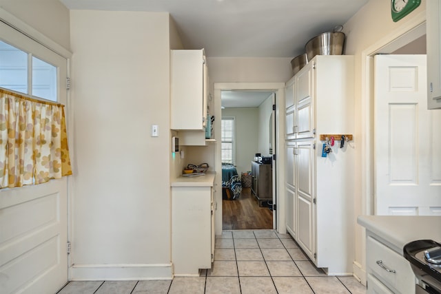 kitchen with white cabinets, light tile patterned floors, and a wealth of natural light