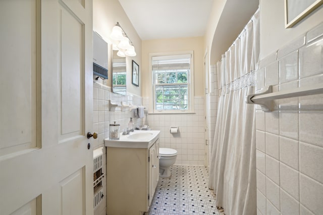 bathroom with vanity, tile patterned floors, tile walls, toilet, and a shower with shower curtain