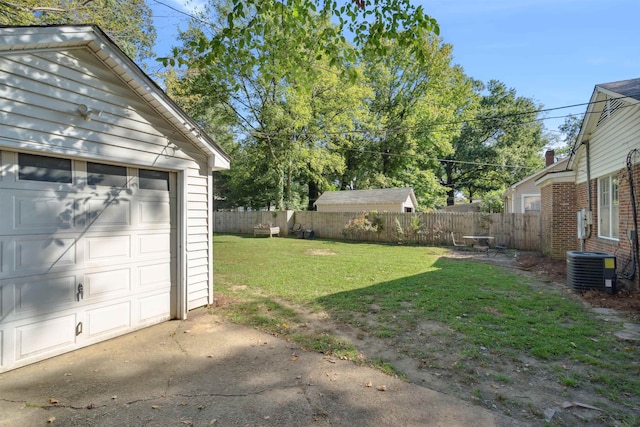 view of yard featuring a garage and cooling unit