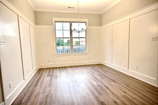 unfurnished dining area with ornamental molding, a chandelier, and hardwood / wood-style flooring