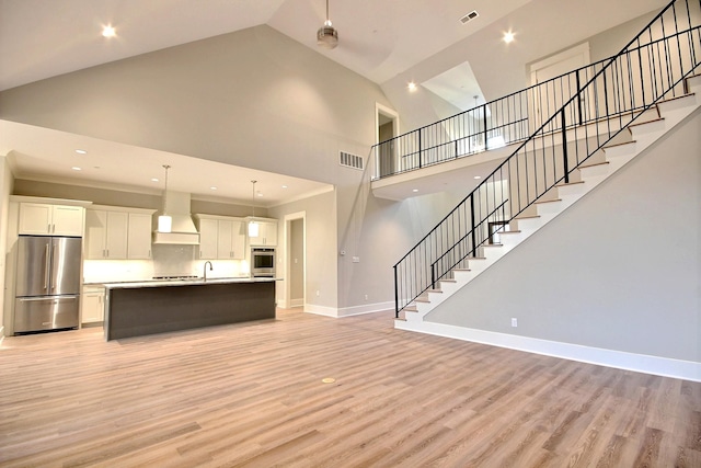 unfurnished living room featuring ornamental molding, high vaulted ceiling, and light hardwood / wood-style flooring