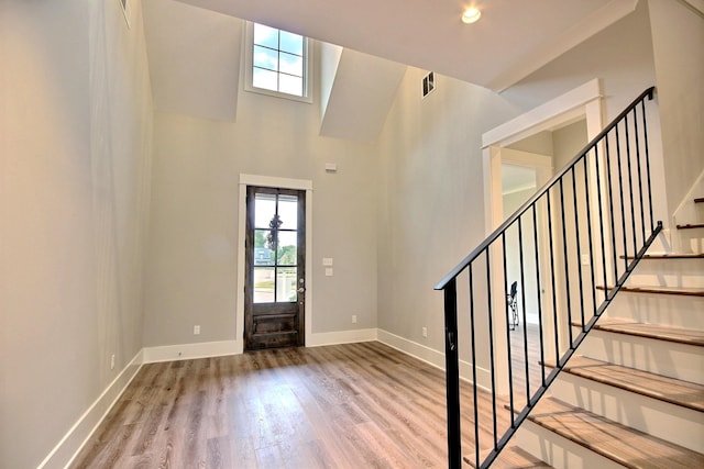 entrance foyer featuring hardwood / wood-style flooring and a towering ceiling