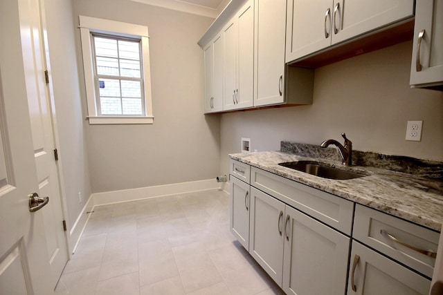 clothes washing area featuring hookup for a washing machine, light tile patterned floors, cabinets, and sink