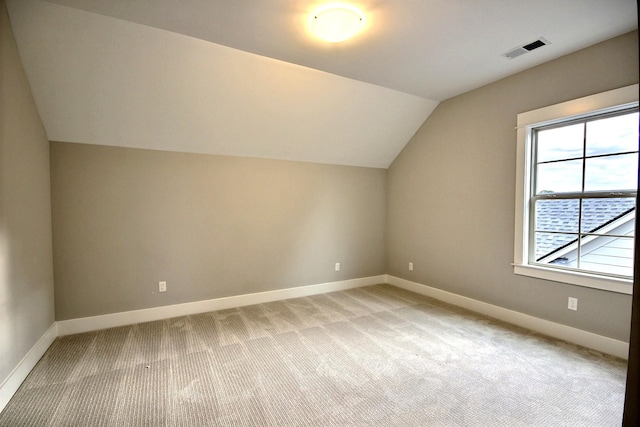 additional living space with light carpet and lofted ceiling