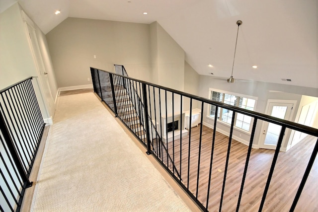 hallway featuring light wood-type flooring and vaulted ceiling