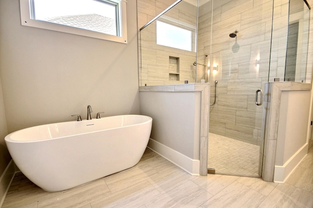 bathroom with a wealth of natural light and separate shower and tub