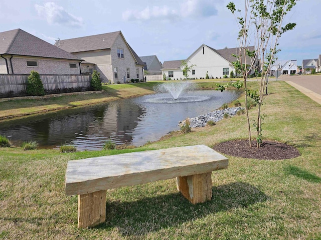 view of property's community featuring a water view and a lawn