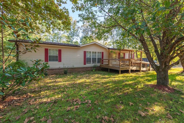 rear view of house with a yard and a wooden deck