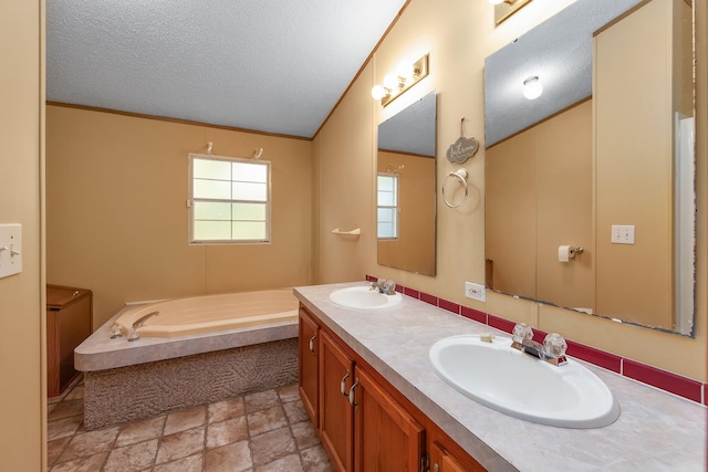 bathroom featuring a textured ceiling, vanity, and a bathing tub