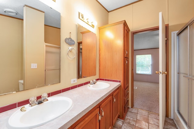 bathroom with a shower with door, vanity, and a textured ceiling