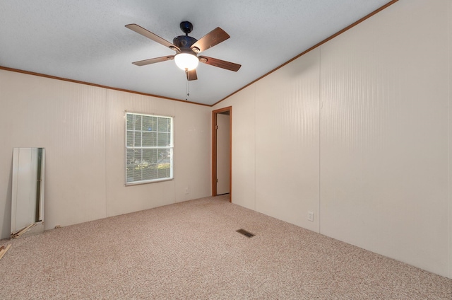 carpeted spare room with crown molding, ceiling fan, and a textured ceiling