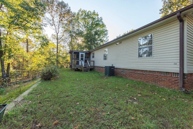 view of yard featuring cooling unit and a deck