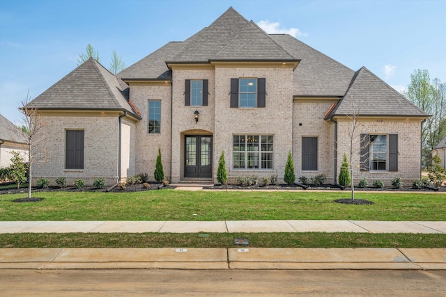 french country inspired facade featuring a front lawn