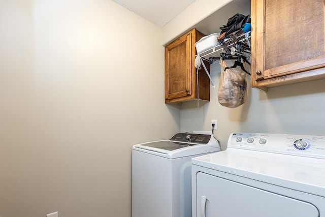 washroom featuring cabinets and washing machine and clothes dryer