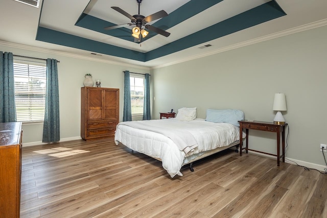 bedroom featuring ceiling fan, a tray ceiling, and hardwood / wood-style floors