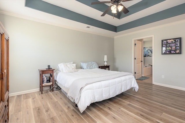 bedroom featuring ensuite bath, ceiling fan, light hardwood / wood-style floors, and crown molding