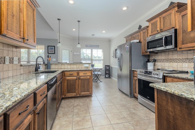 kitchen with decorative light fixtures, appliances with stainless steel finishes, crown molding, and sink