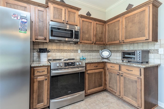 kitchen with light tile patterned floors, stainless steel appliances, light stone countertops, crown molding, and decorative backsplash