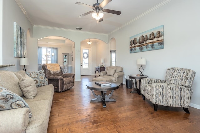 living room featuring wood-type flooring, ceiling fan with notable chandelier, and crown molding