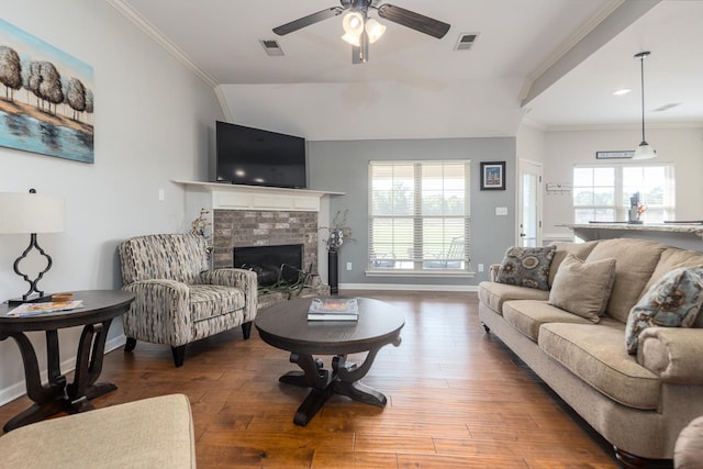 living room featuring ceiling fan, crown molding, hardwood / wood-style floors, and a tile fireplace